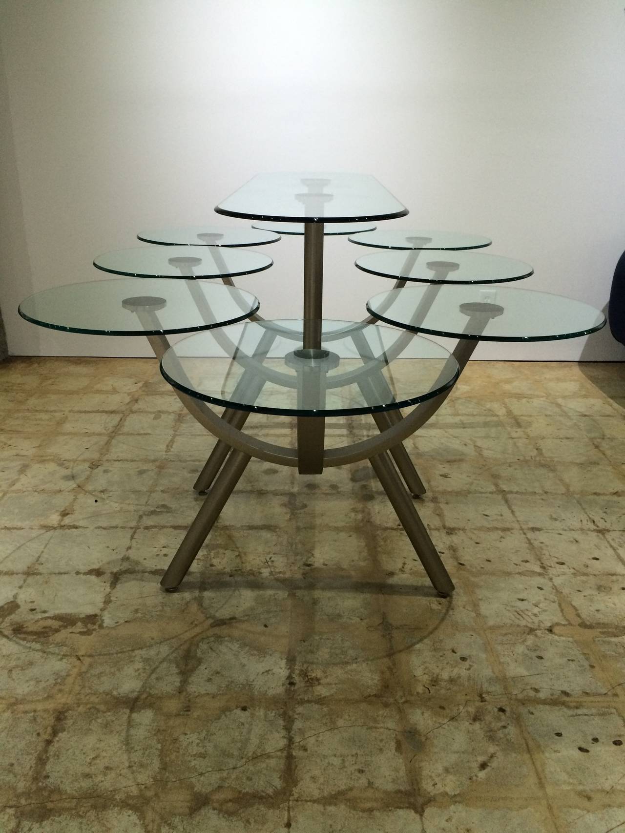 Brushed steel and glass dining table by DIA, Design Institute of America with eight individual glass place settings and an elevated oblong glass serving shelf.

Additional dimensions:
20