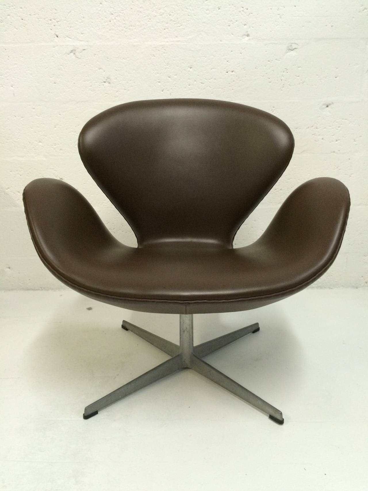 Pair of original 1973 brown Naugahyde swan chairs designed by Arne Jacobsen for Fritz Hansen.

reupholstery reccommended