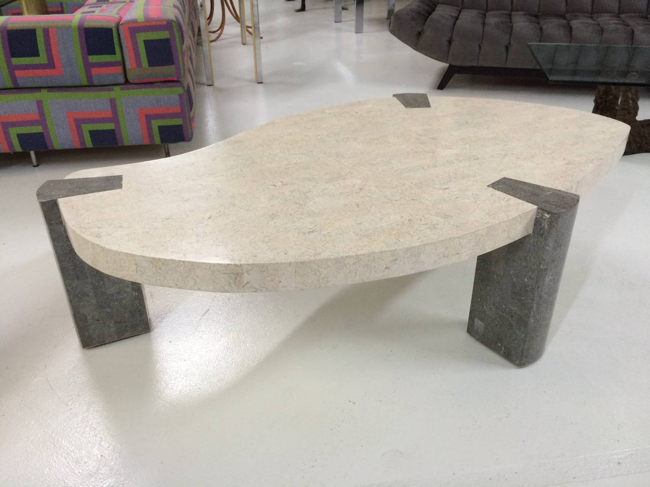 Biomorphic coffee table in white and grey tessellated marble with inlaid brass banding at the base by Maitland-Smith.