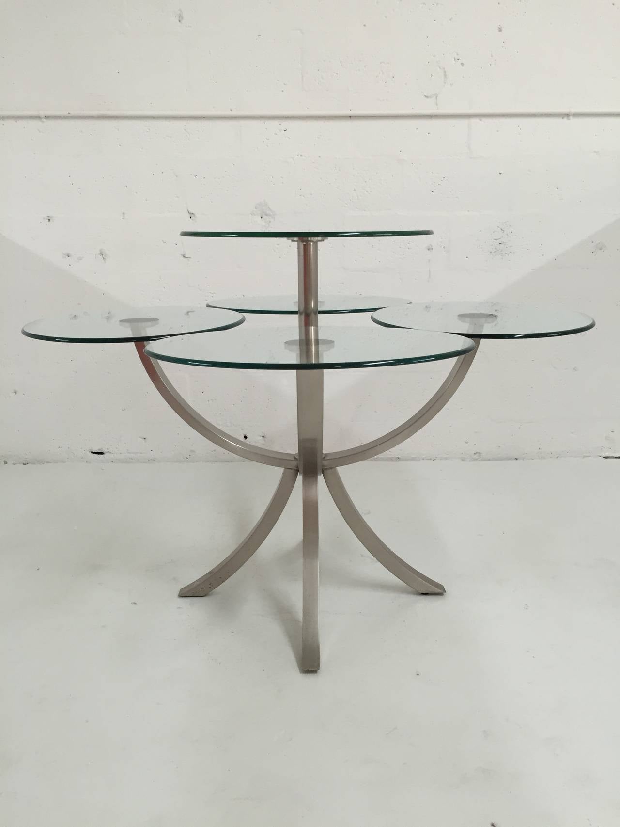 Brushed steel and glass dining table by DIA, Design Institute of America with four individual oblong glass place settings and an elevated round glass serving shelf.

Additional Measurements:
24'' - width of place setting.
20