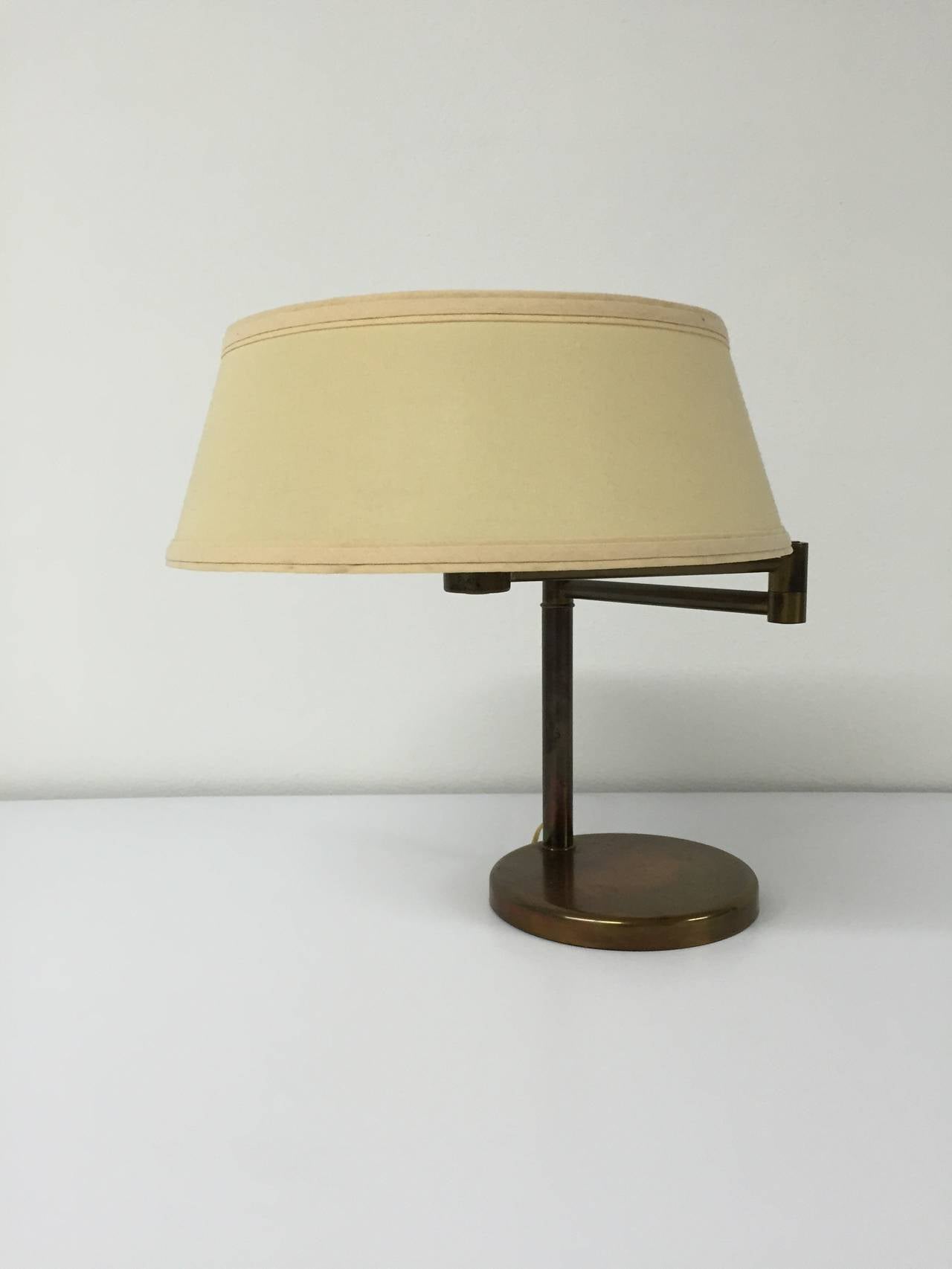 Swing arm desk lamp in brass with original linen shade and metal diffuser by Walter Von Nessen for Nessen Studio.