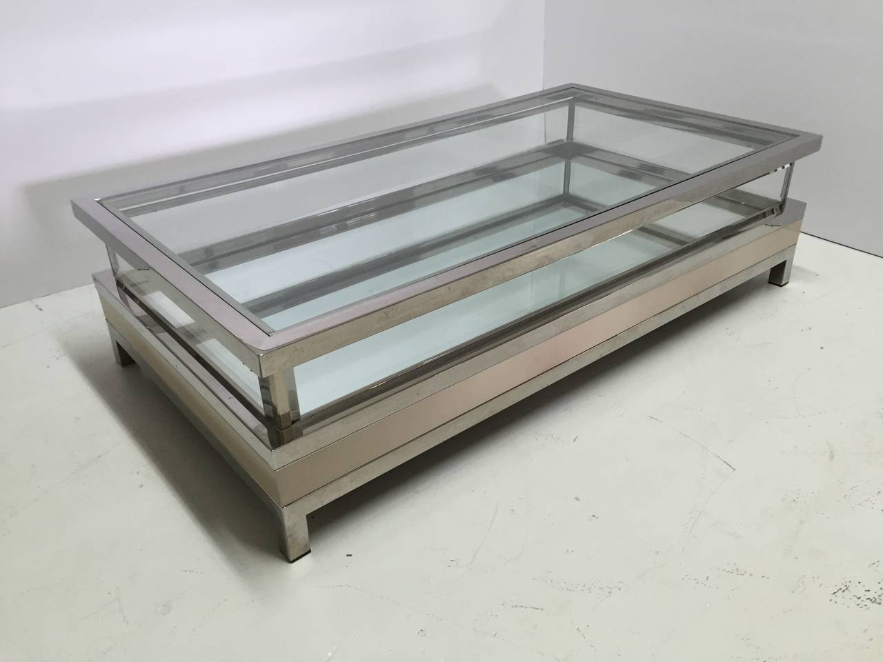 Coffee table in polished steel, glass, perspex and cream enamel with mirror bottom by Maison Jansen. Top slides open for access to inside and when closed, can be locked with key.