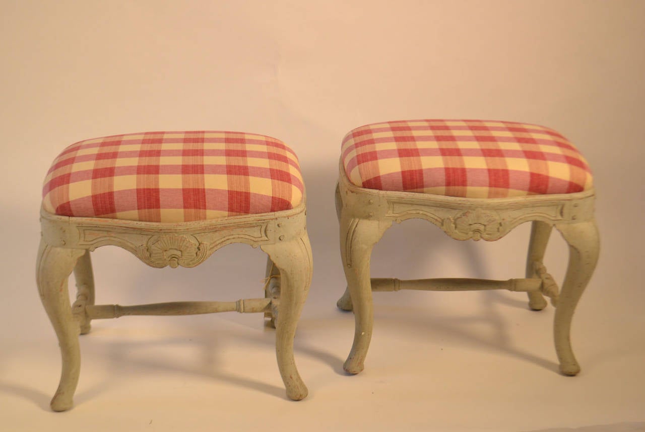 Pair of 19th century Swedish footstools with a central shell on the apron and cabriole legs which are supported by a spindle shaped stretcher.