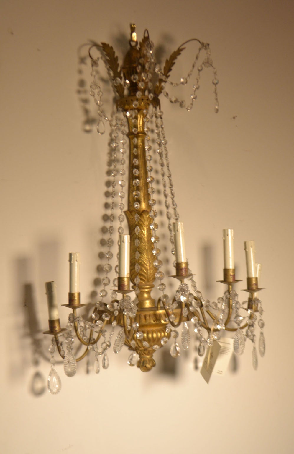 Pair of Italian 20th century (circa 1940) giltwood and crystal sconces with acanthus leaves, gadrooned urn and stylized planette with fluted stem, crystal drops and seven lights with faux candles.