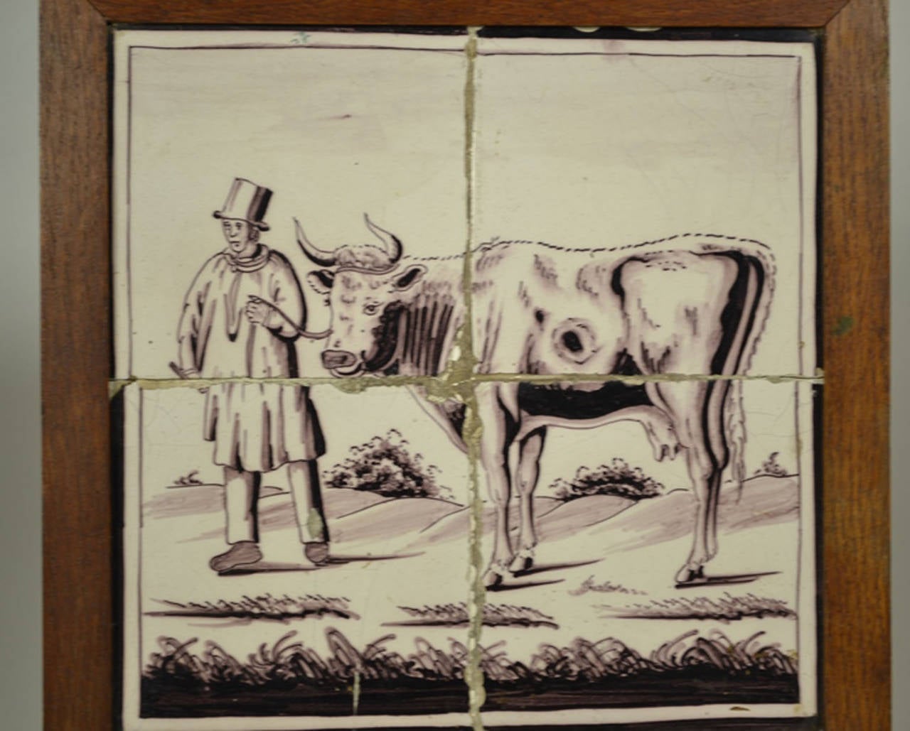 Delft tile wall picture of a cow led by a gentleman, 18th century. The color of the tile is a manganese based purple which was introduced in the later part of the 17th century and used as an alternative to the typical blue color. These tiles