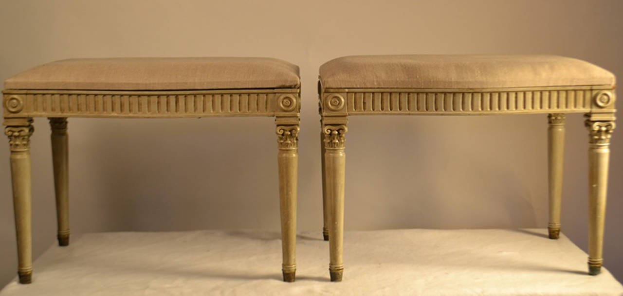 Louis XVI style footstool with Corinthian column tapered legs and a cannelure apron with corner rosettes.