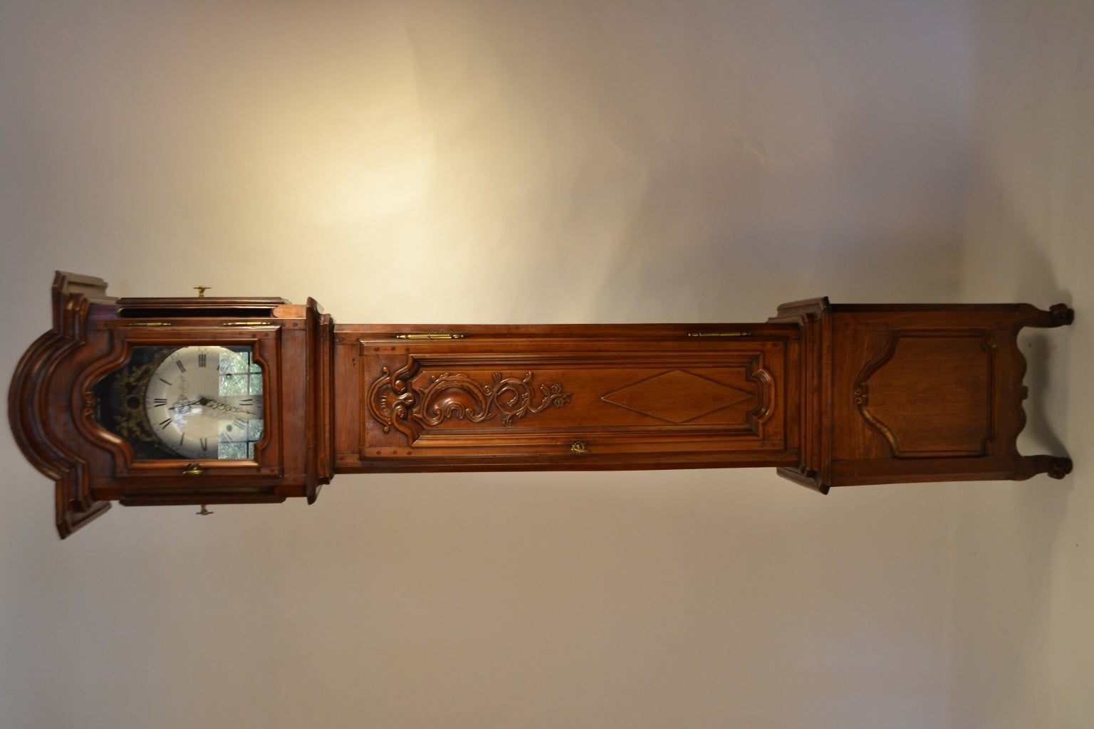 Cherry floor clock from Brittany (Rennes). The bonnet or pediment of the clock as well as the base features carved scroll work which frames the glass and base. There are two easy side access panels with glass at the top. The body of the clock