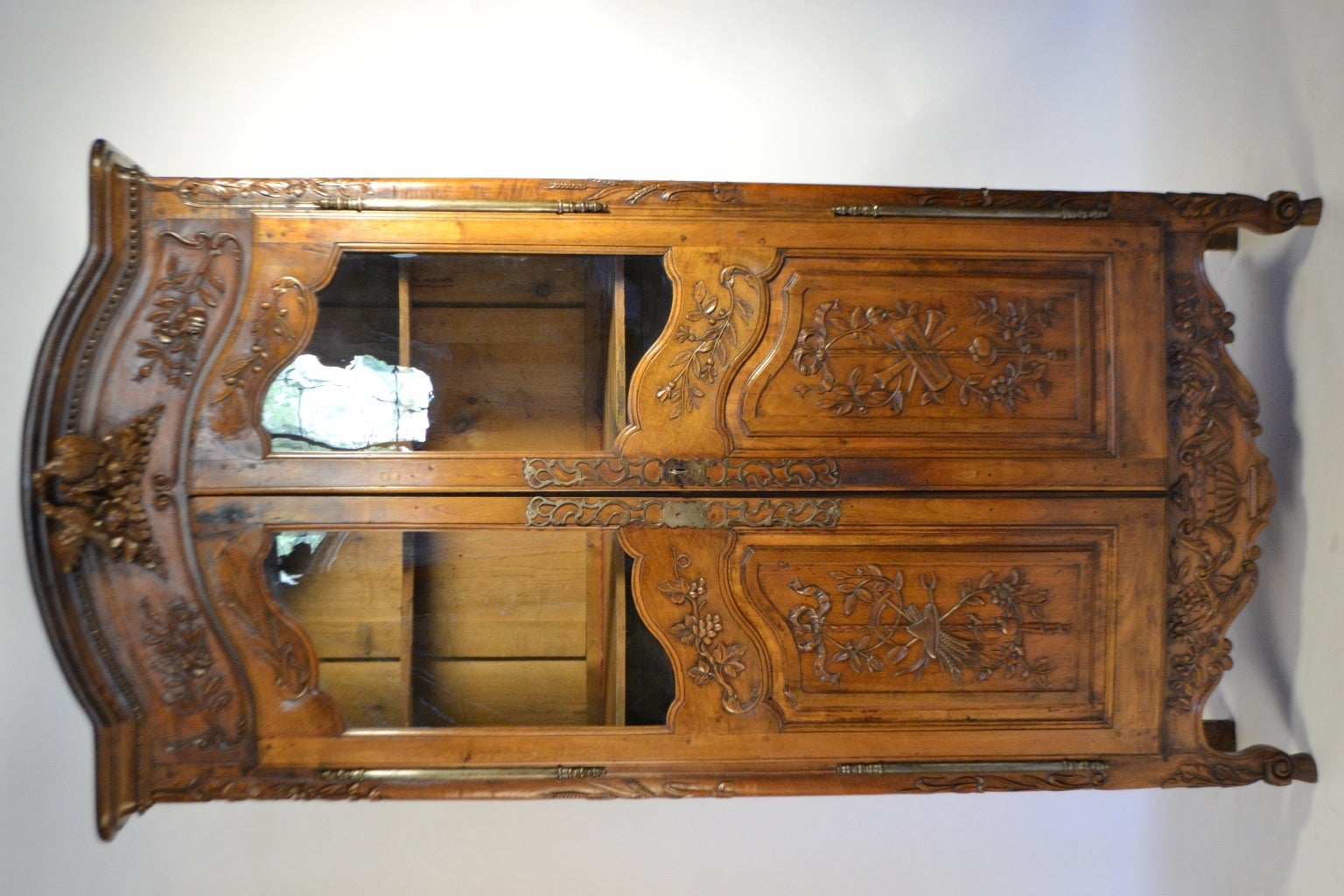 Wonderfully carved walnut armoire in the Provençal style. Just below the simple cornice is a beaded border that frames an attribute of love, two dove birds. The sides of the armoire and the framing of the doors present a grape vine and wheat motif.