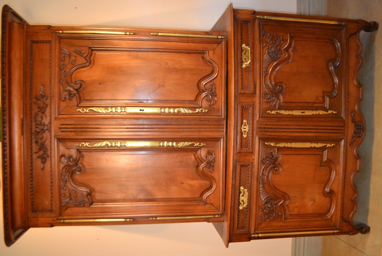Lovely buffet deux-corps from Normandy with beautiful carved detailing of a floret and grain motif on the cabinet doors, an urn and floret design on the cornice with a bell flower border design, embellished with elongated hinges with turned ends and