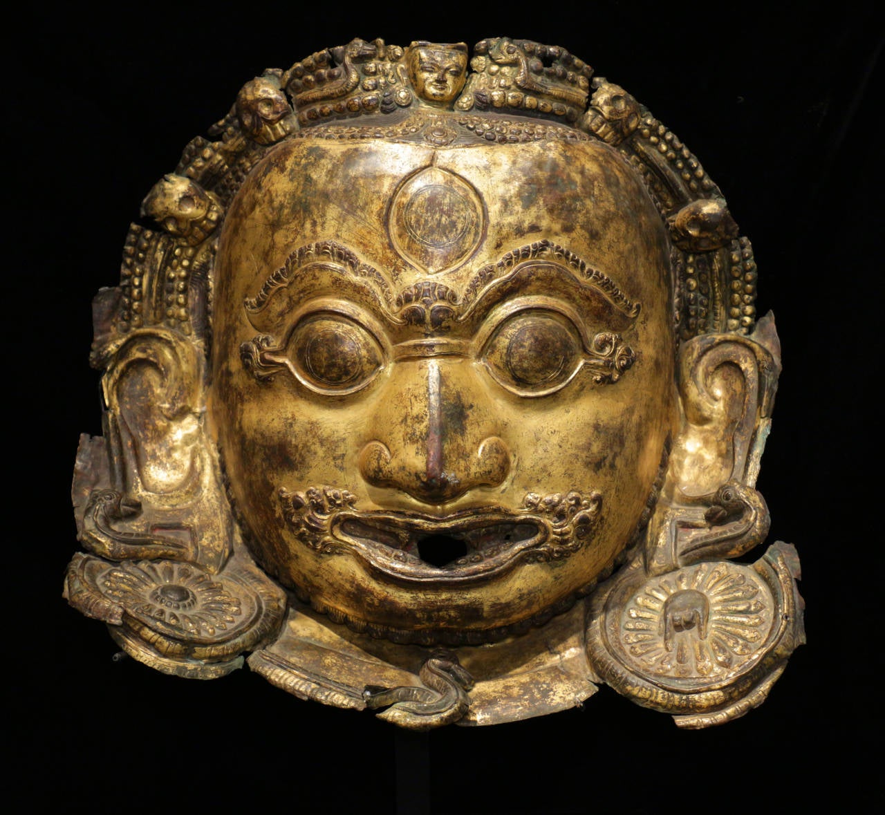 15th Century Bhairava Mask from Nepal. Gold gilt on repousse copper. Bhairava is one of the main protector deities of the Kathmandu valley. On the auspicious day, once a year, local rice beer would be offered to worshipers who would drink it as it
