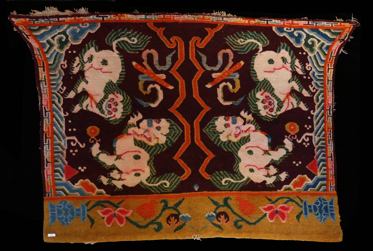 This rare Tibetan saddle rug features images of Snow Lions. It was reserved for a high lama (Buddhist teacher) to use when he rode on a yak. The intricate design depicts white snow lions the mascots of the Tibetan government, all wool circa 1930