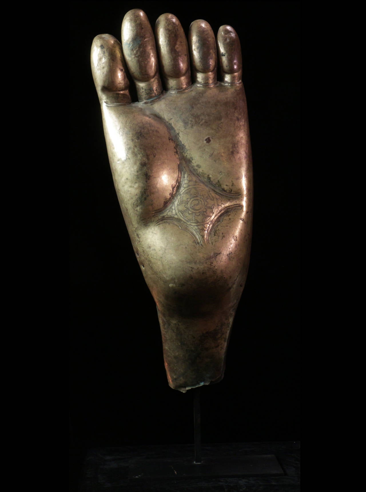 Gilt copper foot from a monumental Tibetan temple Buddha. 16th or 17th century. Inscribed with the sacred Buddhist mark of the wheel of the law (Dharmachakra).