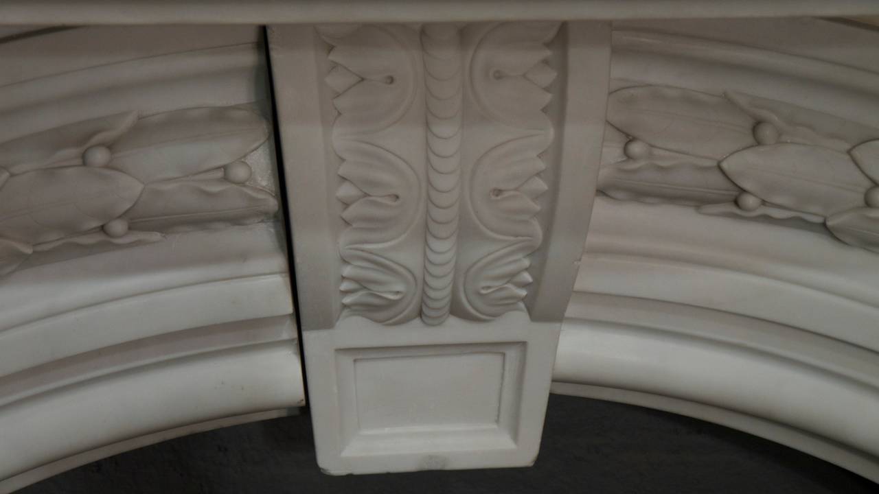 A large statuary carved white Victorian arched marble.