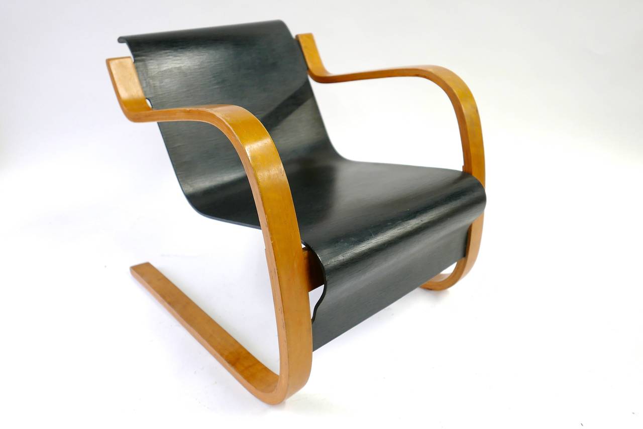 Designed by Alvar Aalto in 1932. The laminated birch frame produces a unique cantilevered shape; creating an armchair without straight lines. The seat and back are molded maple plywood. The fluidity of this design creates a soft line using