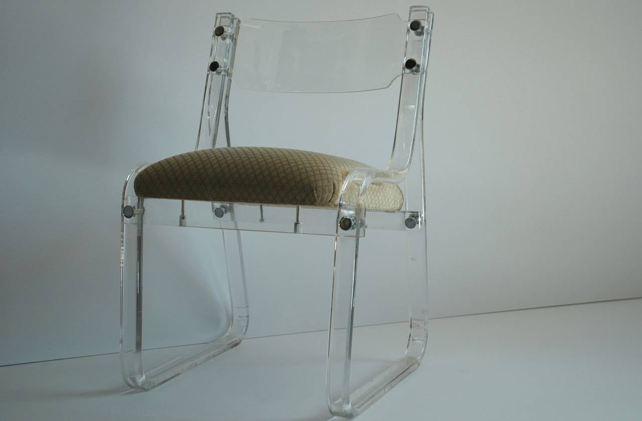 Lucite chair with original vintage upholstered seat.  This side chair features a slightly curved lucite back and chrome button fittings. Attributed to Karl Springer.