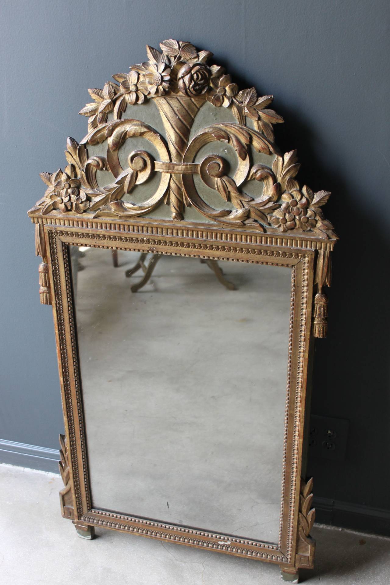 Lovely giltwood mirror in the style of Louis XVI from France in the 19th century. This mirror features lovely hand carving and gilt and painted wood.