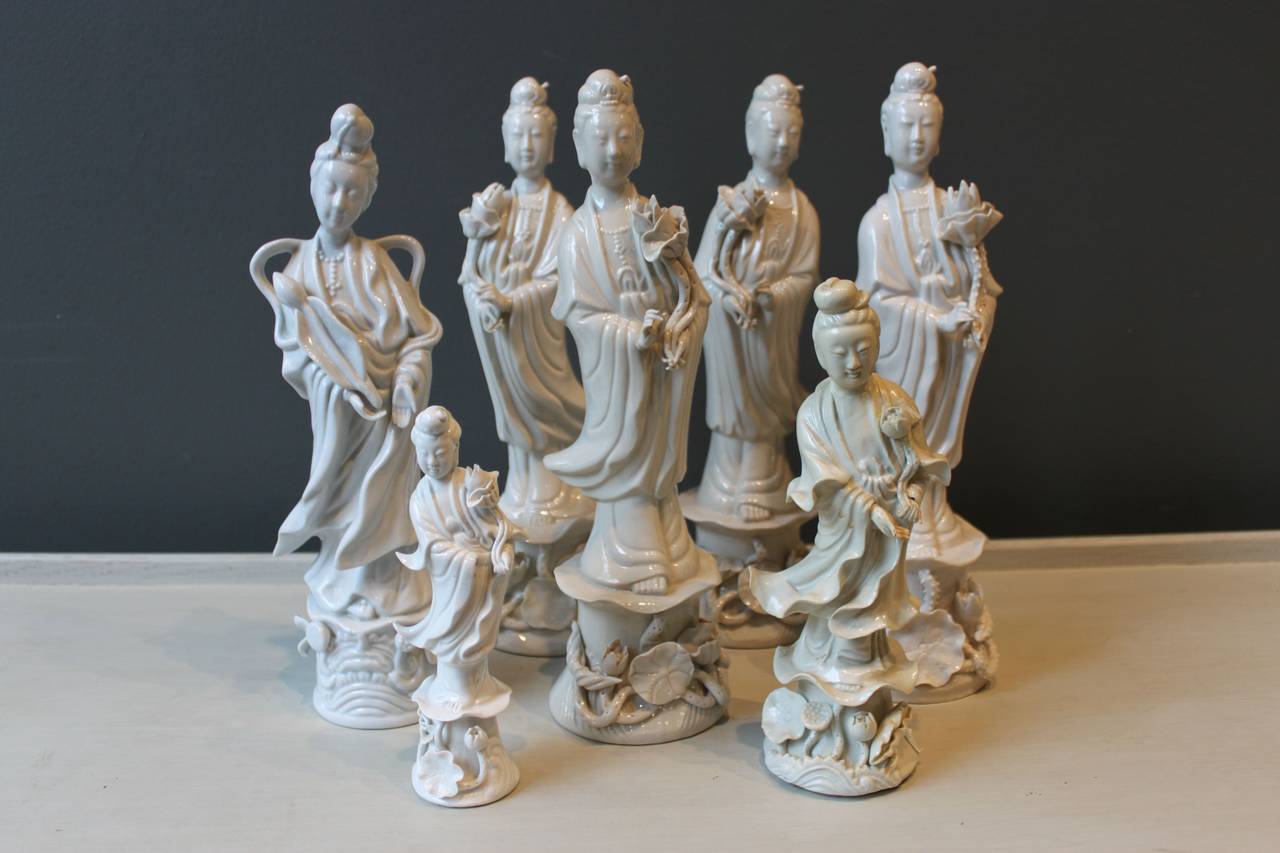 Assembled collection of seven (7) Blanc de Chine Guanyin figures.  The figures are of varying age, size and condition. Slight coloration variation in shades of white.  Several of the figures are marked.

Largest Guanyin measures 12.25