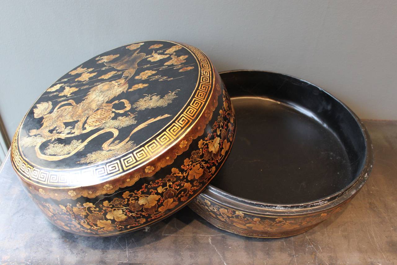 Beautifully detailed and exceptionally large Chinese export lacquered black and gold storage box. This exquisitely detailed box features Foo dog decoration on the lid and Greek key border.