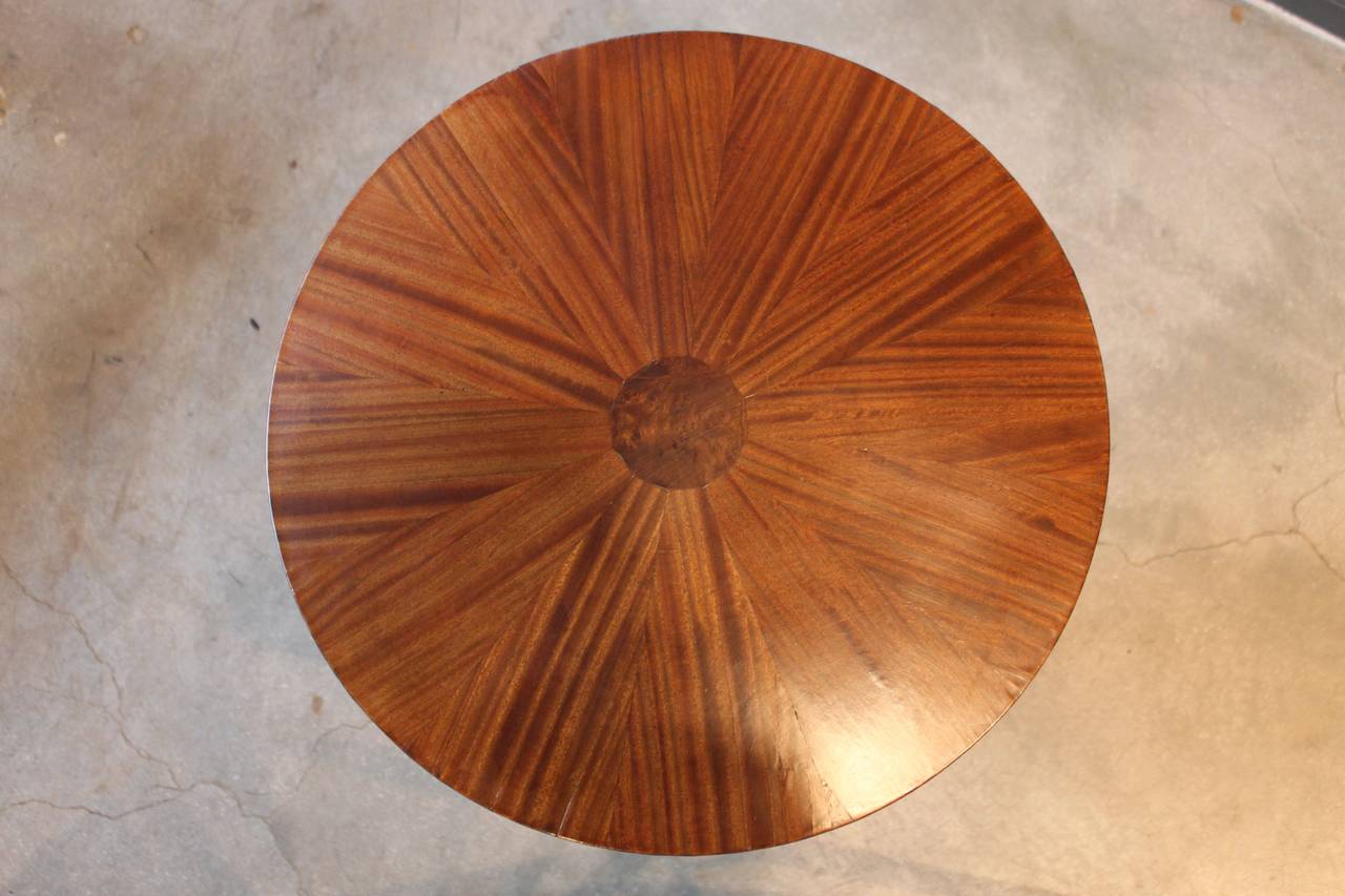 Schön furnierter runder Art Deco Beistelltisch. Die Tischplatte ist mit einem Furnier im Starburst-Muster versehen:: die anmutig geschwungenen Beine enden in Messingfüßen.