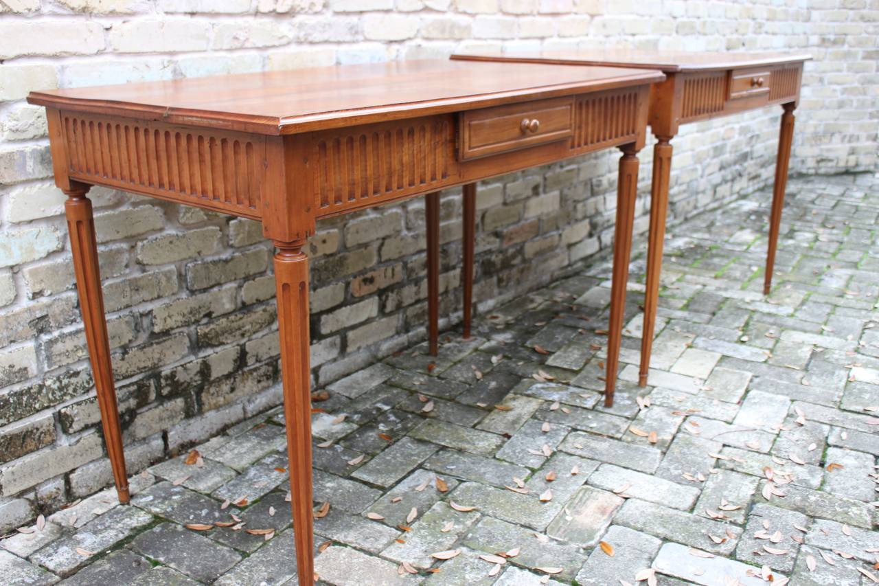 A handsome pair of French tables each with a single drawer on turned legs. The tops of the tables have been restored and the tables are in overall very good antique condition.  These tables would work serve nicely as end tables or  work well as