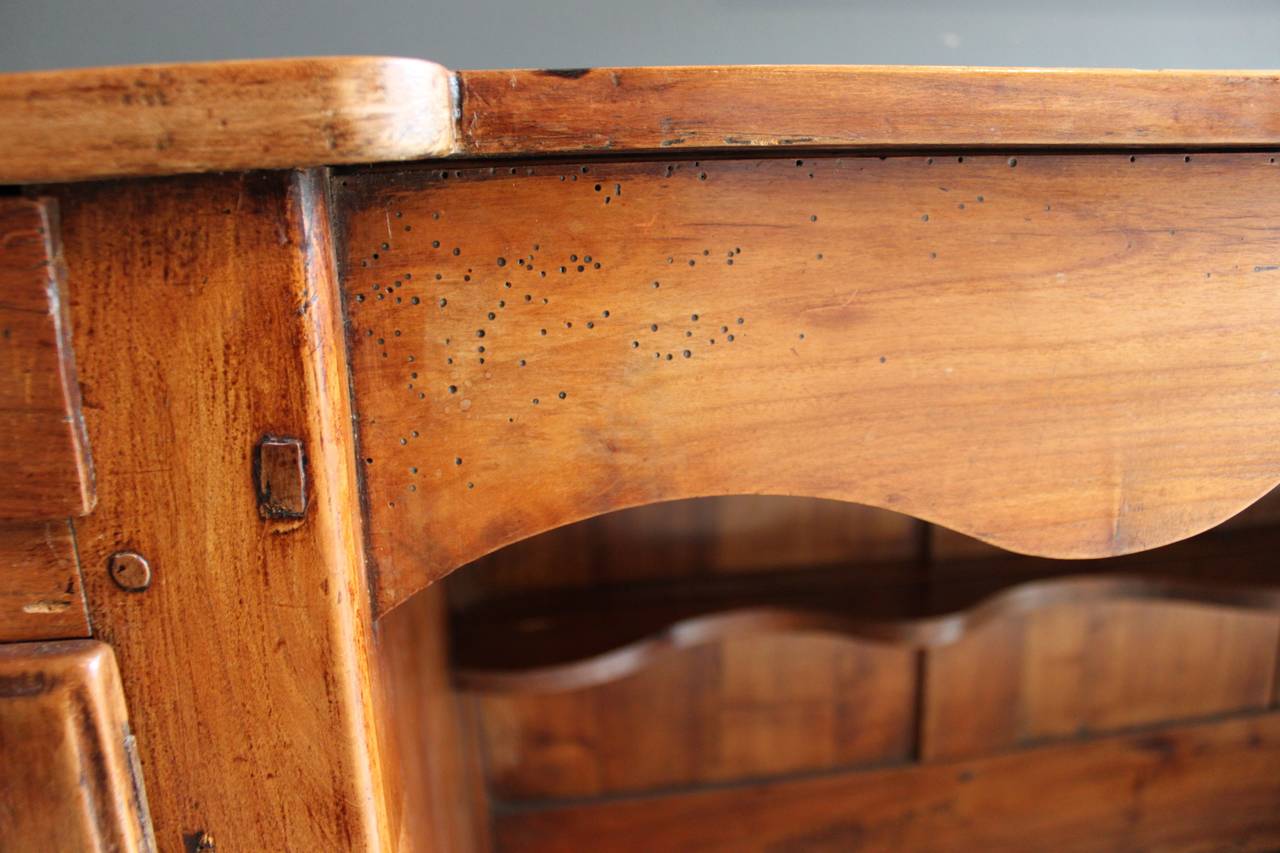 Lovely 19th century or earlier Louis XV-style French cherry sideboard or server. This piece has a wonderful warm patina and has one door and one drawer on each side. The piece also has an open space in the center for plate display and storage. This