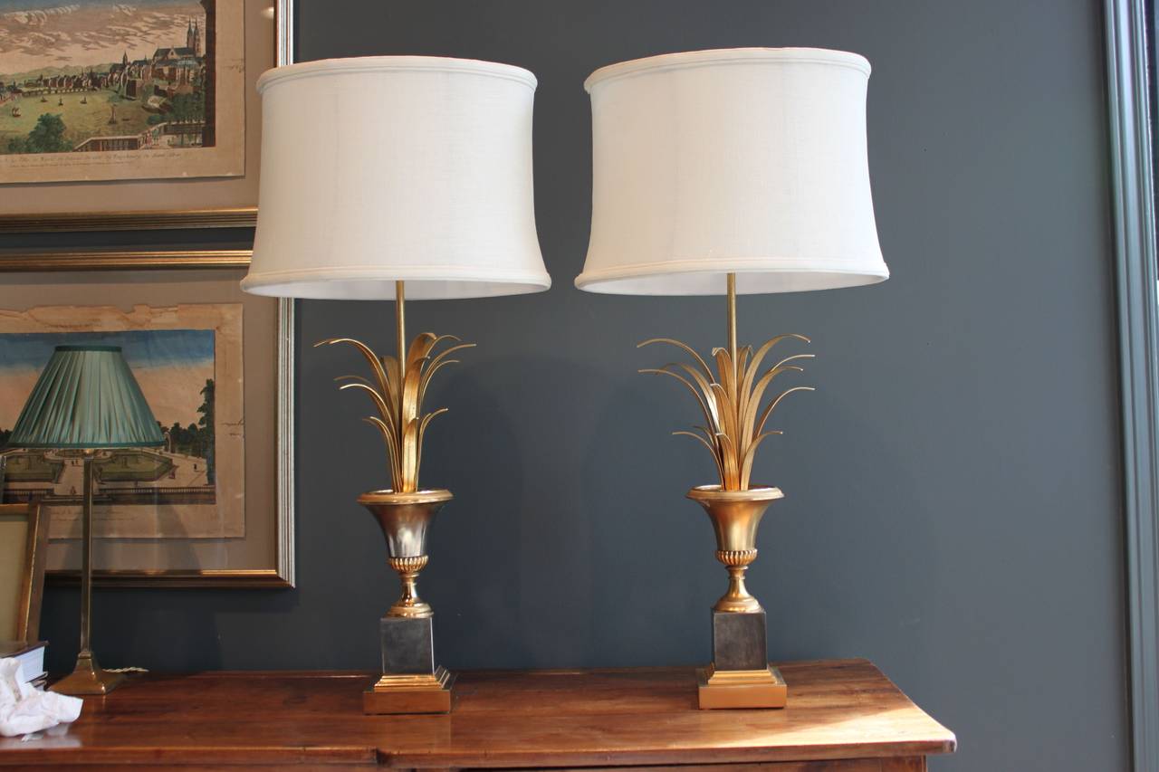 Pair of vintage brass lamps in the form of an urn with fronds. These French lamps are in the style of Maison Charles and have been newly wired. The measurement to the top of the finial is 29