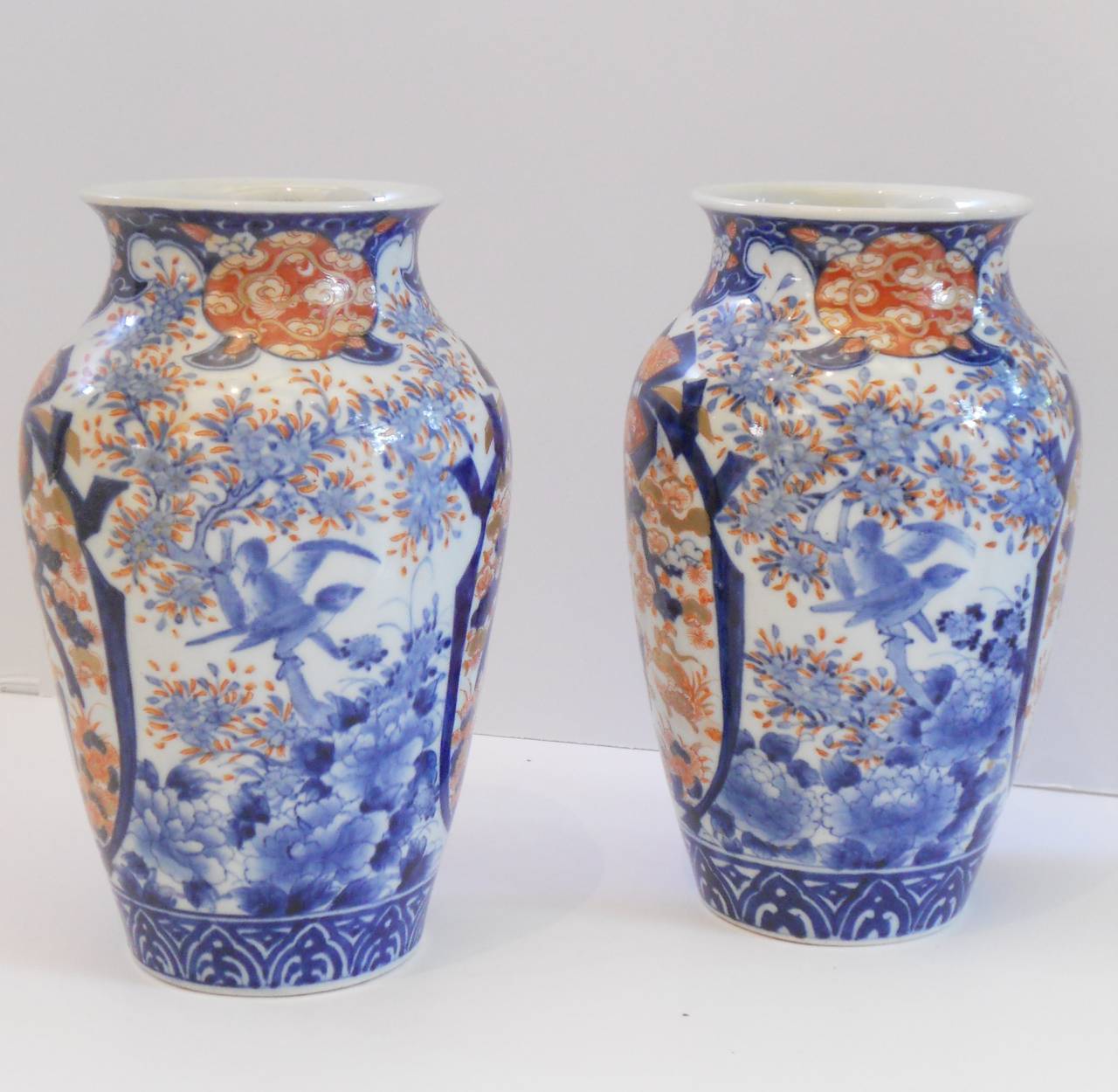 Pair of signed Imari vases of balust form with brilliant blue and red coloration. 
Symbols inside the cartouche include pine which is the symbol of everlasting strength and ability to endure and an incense burner symbolizing veneration of the