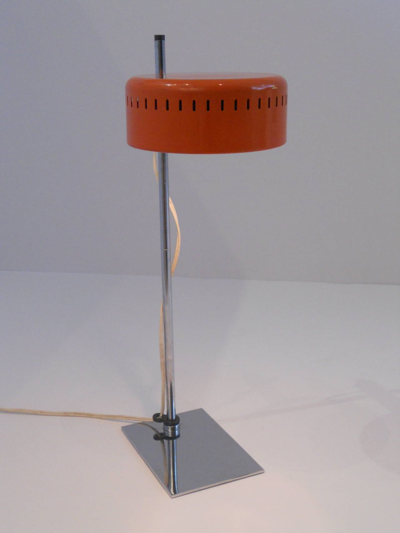An original Robert Sonnemann desk lamp with and original orange metal shade and chrome base. Lamp retains the original maker's tag.