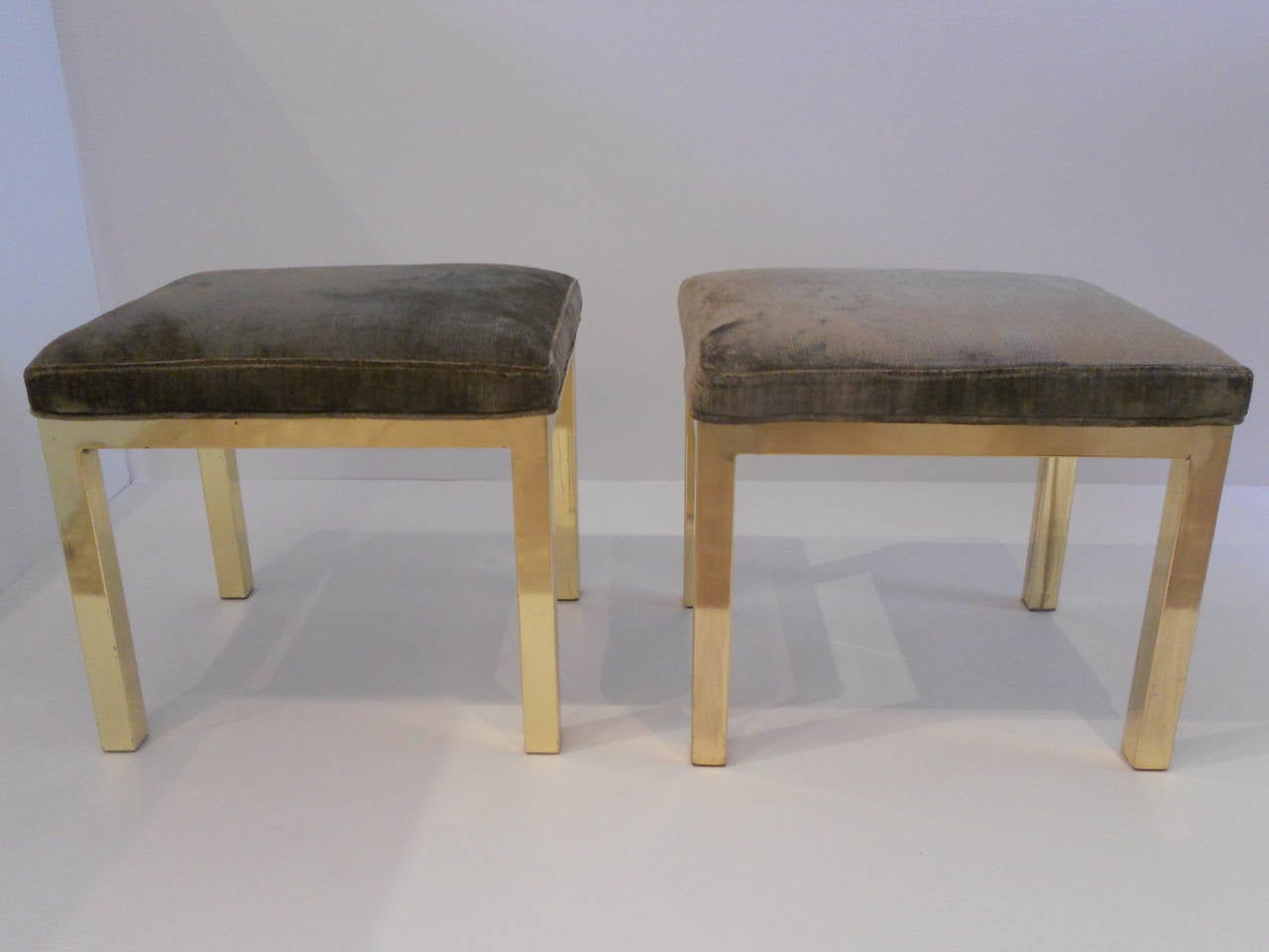 Vintage pair of brass stools or ottomans with newly upholstered seats in a gray linen velvet.