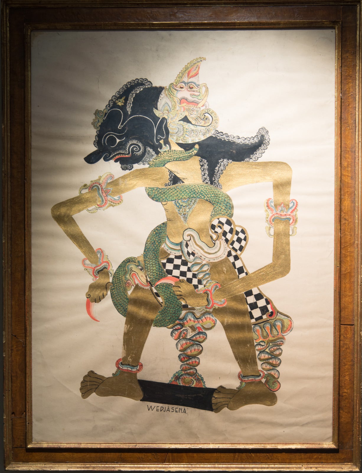 Early 20th century Indonesian painting on paper depicting Waylang Kulit also known as a shadow puppet.

This folk painting on paper is under glass with a lovely aged burled wood frame. The painting is likely early 20th century and the frame is