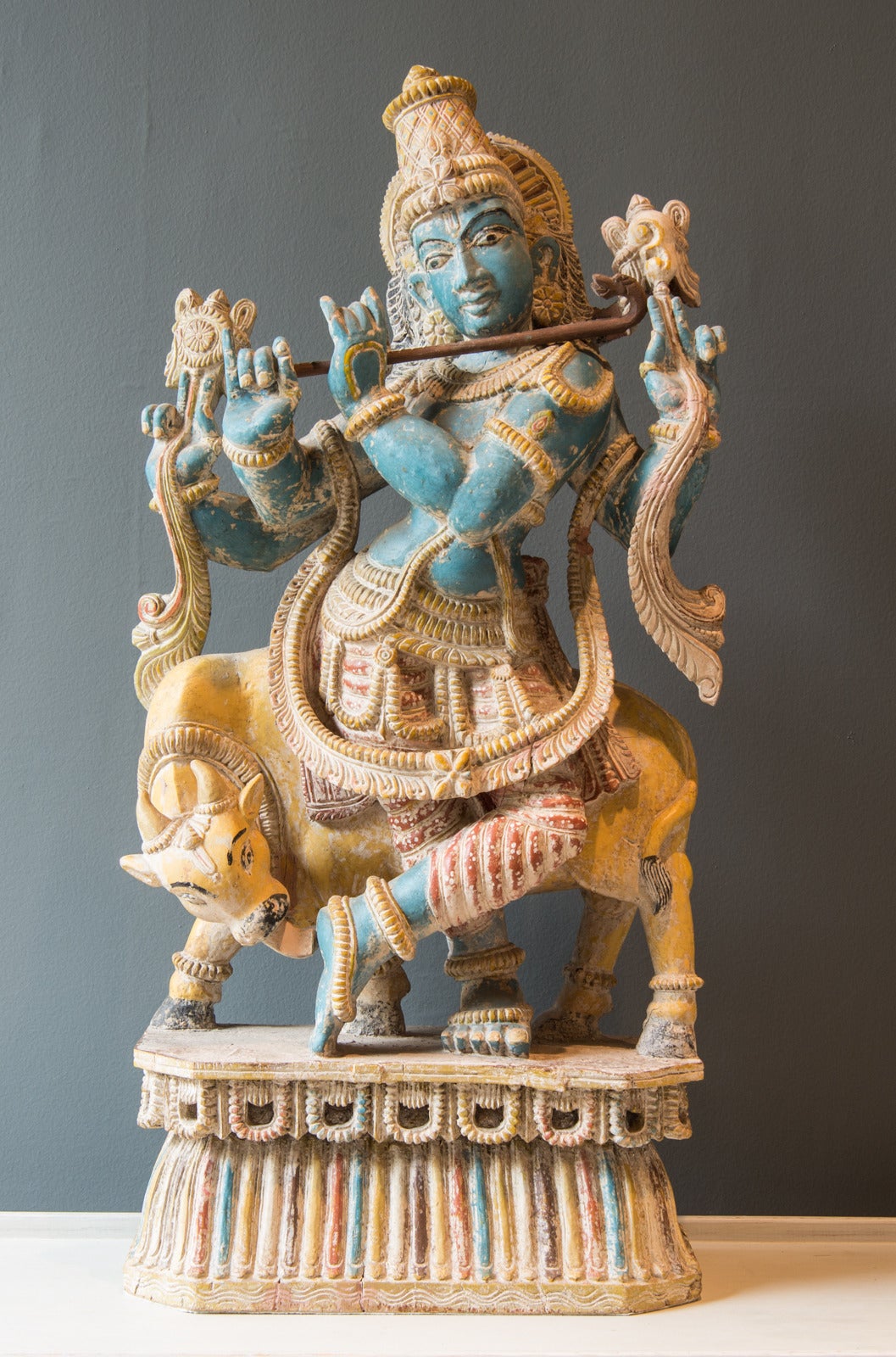 This brightly-colored polychrome statue is made from painted wood clay or plaster and likely depicts the Hindu god, Vishnu. Also depicted is a cow in a wonderful shade of yellow. Vishnu is a diet believed to have descended from heaven to earth in