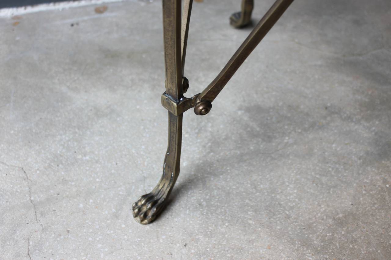 Pair of early 20th century neoclassical style bronze gueridons with inset white marble tops, raised on straight legs and animal paw feet, with three vertical X-form stretchers. These gueridons are wonderfully elegant and in the style of Maison