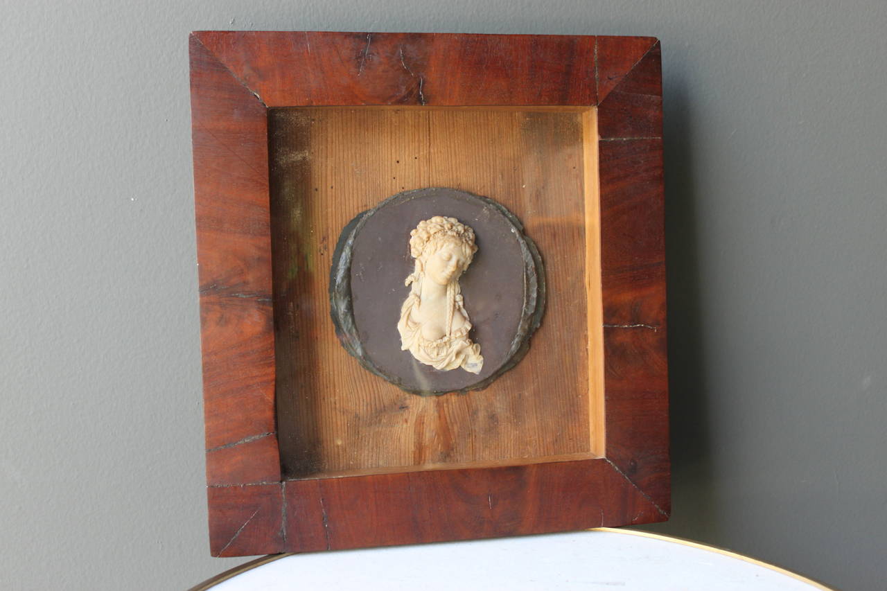 Beautifully detailed bas-relief wax portrait of a lady framed under original glass.
The intricate detail of this piece is seen in the lace of her gown, tendrils of her hair and the lovely facial detail. Unsigned.
This piece is a fine example of