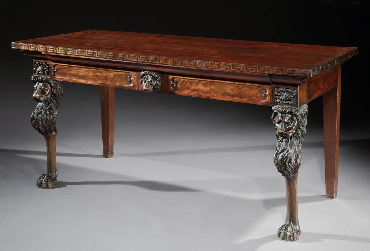 A superb George IV mahogany serving table with matching pedestal cupboards. The rectangular top table has a brass inlaid Greek key edge, above a panel frieze with central drawer and carved central mask flanked by carved anthemion's. The sarcophagus