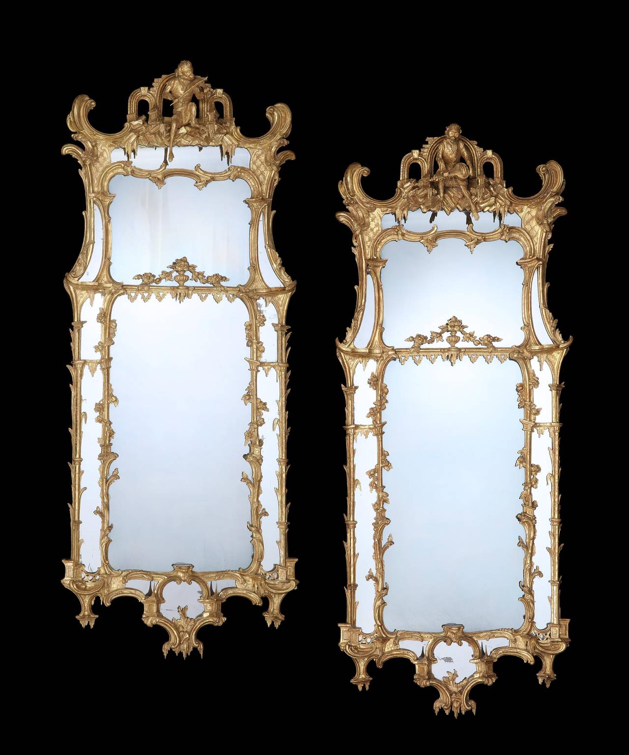 A Pair of George II carved gilt-wood Pier Glasses in the manner of Matthias Lock. This pair of mirrors encapsulates the highly imaginative fanciful design of the french picturesque that prevailed in the mid-18th century with the nautilistic palm