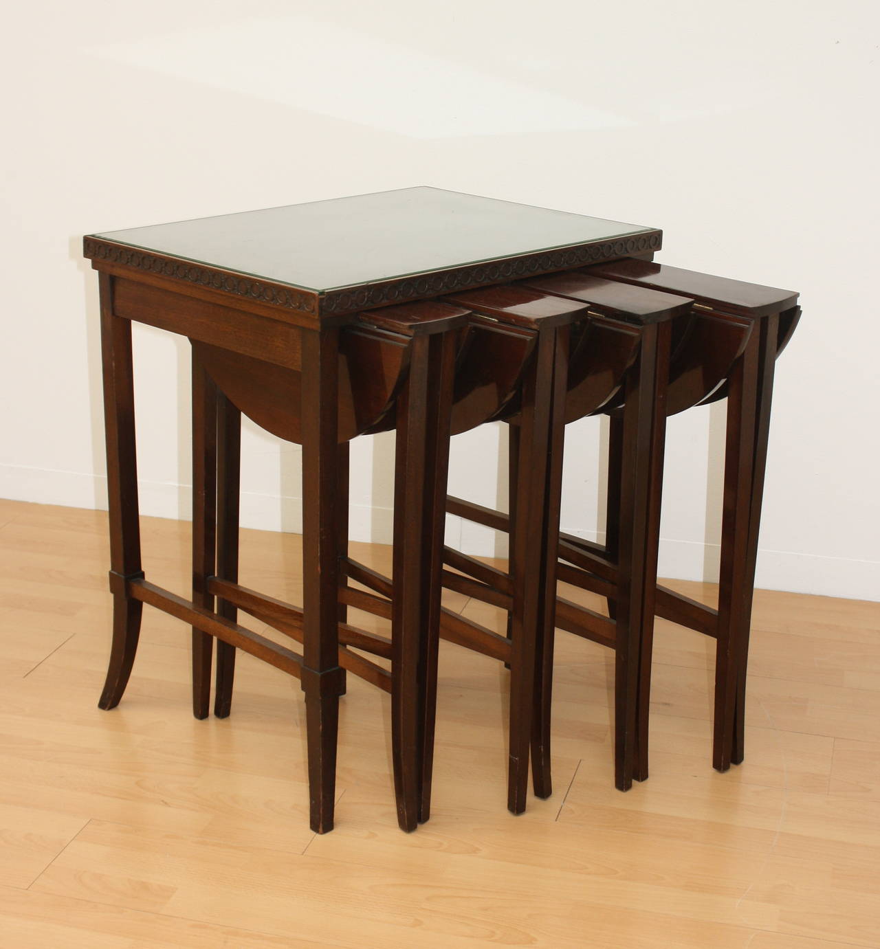 Useful mahogany end Table with glas top and four rounded drop-leaf nesting tables.
Each round Table: Height: 73cm, Diameter: 49cm.