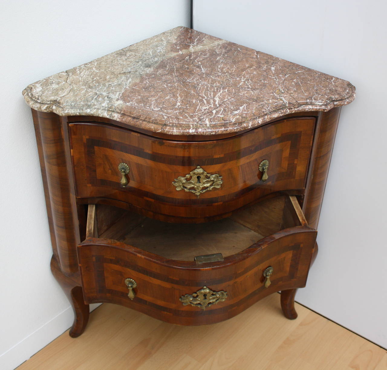 An handsome Baroque two-drawer corner commode with marble top. Bow front.
Without key.