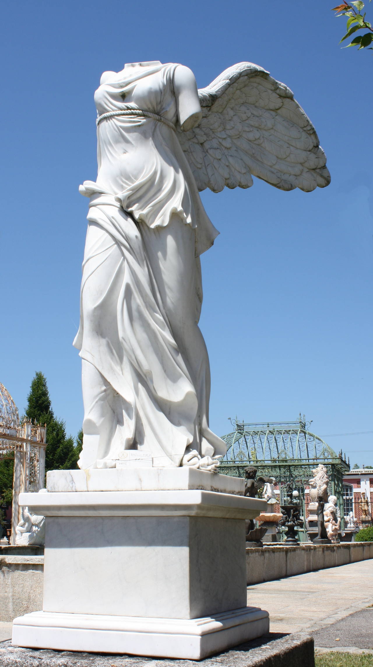 La Victoire de Samothrace, also called Nike of Saothrace or winged Victory, is after the great masterpiece of hellenic sculpture. Lifesize statue on pedestal, white marble. 
Statue: H 160cm with wings, (140cm without), W 44cm, D 45cm.
Pedestal: H