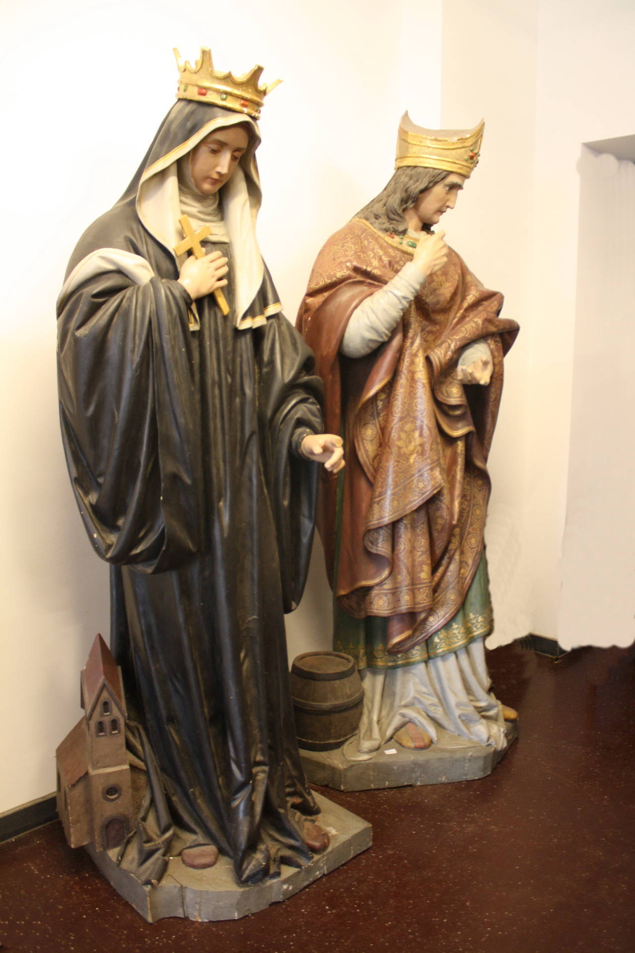 Pair  larger-than-life Sculptures, carved wood and polychrome "Nazarene" Barbara with Tower and Rupert with salt Barrel. 
Barbara: H 220cm, W 70cm, D 65cm.
Rupert: H 220cm, W 95cm, D 70cm.
Barbara is missing the pointer finger on the