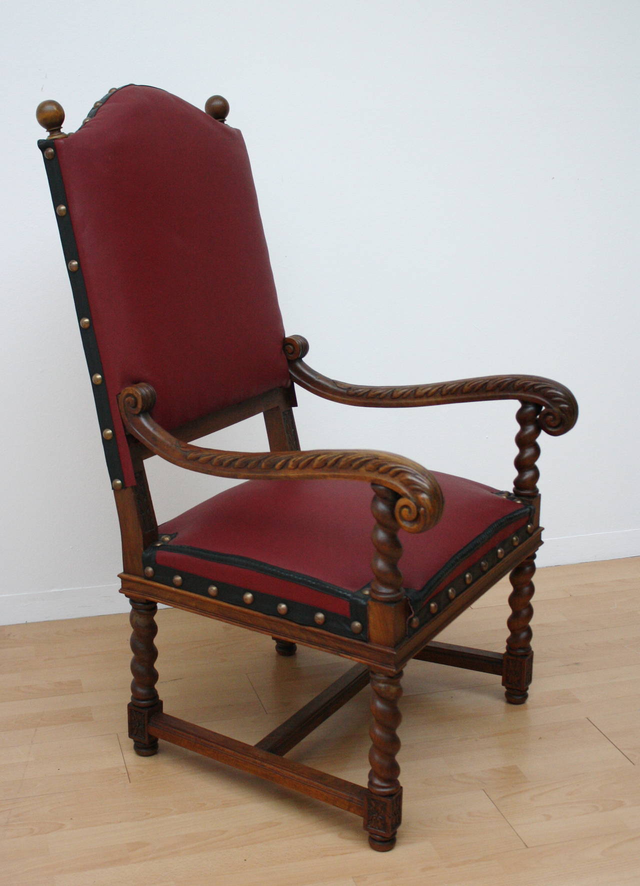 An high backed Armchair, beech Wood carved and prim, back and seat upholstered with red composition Leather.