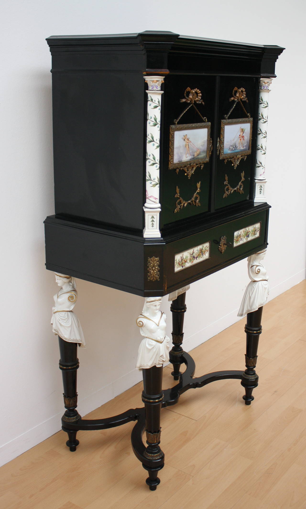 Beautiful and elegant lady's desk "Bonheur du jour."
Ebonized wood, legs with four porcelain lady's. The draw can be converted into a writing place. Top flanked with porcelain columns, on the doors two porcelain paintings and metal