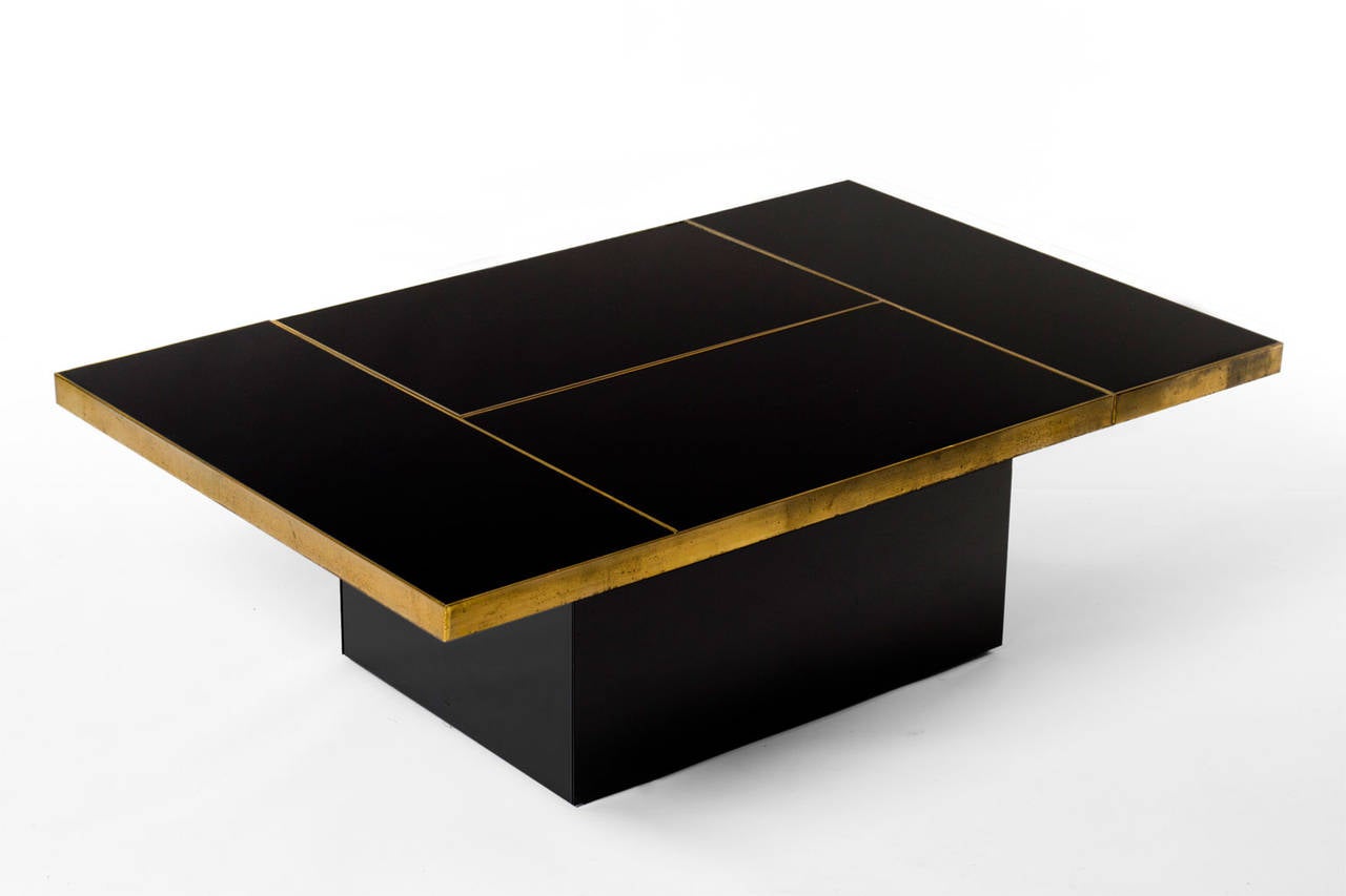 Stunning geometric cocktail table, 1970’s. High quality brass framing and black mirror top and base. The top can slide open and hides a incredible mirrored bar with two black lucite shelves. A real conversation piece in the style of Willy Rizzo. In