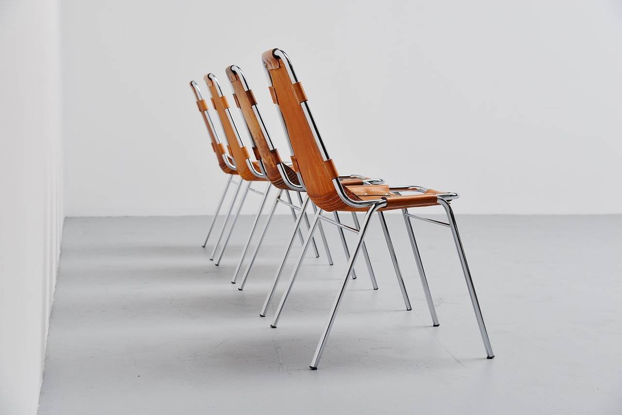 Nice set of 4 original side/dining chairs by Charlotte Perriand for Ski resort Les Arcs in 1960. This is for a set of 4 natural leather chairs in good original condition with wonderful patina to the leather. They have chrome tubular frame and high