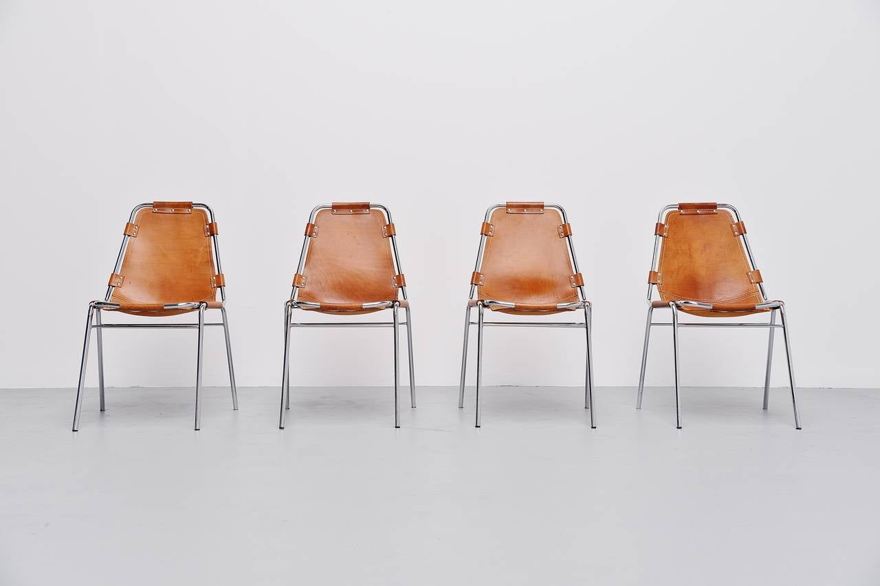Very nice set of four original side or dining chairs by Charlotte Perriand for Ski resort Les Arcs in 1960. This is for a set of four rare natural saddle leather chairs in good original condition. They have chrome tubular frame and high quality