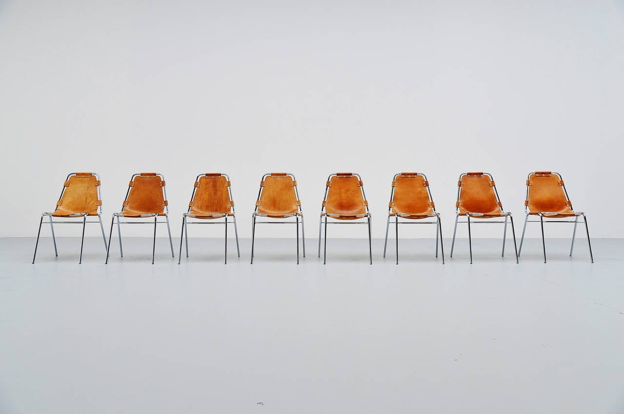 Very nice set of eight original side or dining chairs by Charlotte Perriand for Ski resort Les Arcs in 1960. This is for a set of eight rare natural saddle leather chairs in good original condition. They have chrome tubular frame and high quality