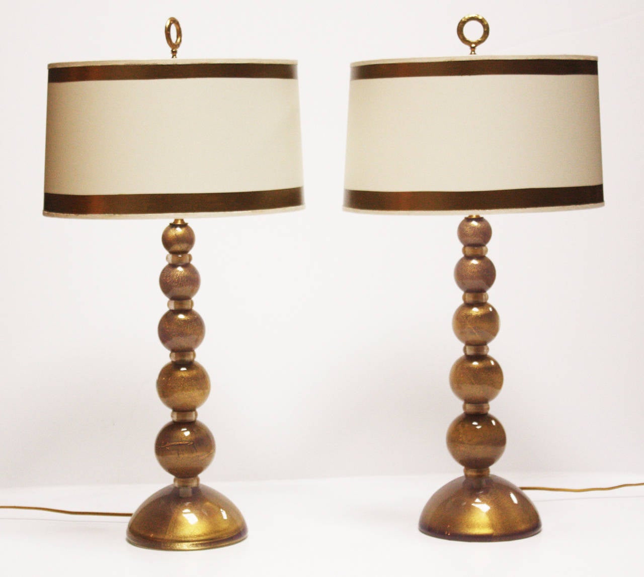 Pair of Mid-Century handblown Murano glass lamps in stack design. The larger elements are crafted of heavily gold infused paperweight glass in shades of lavender to light purple. The separators are crafted of clear glass also with gold inclusions.