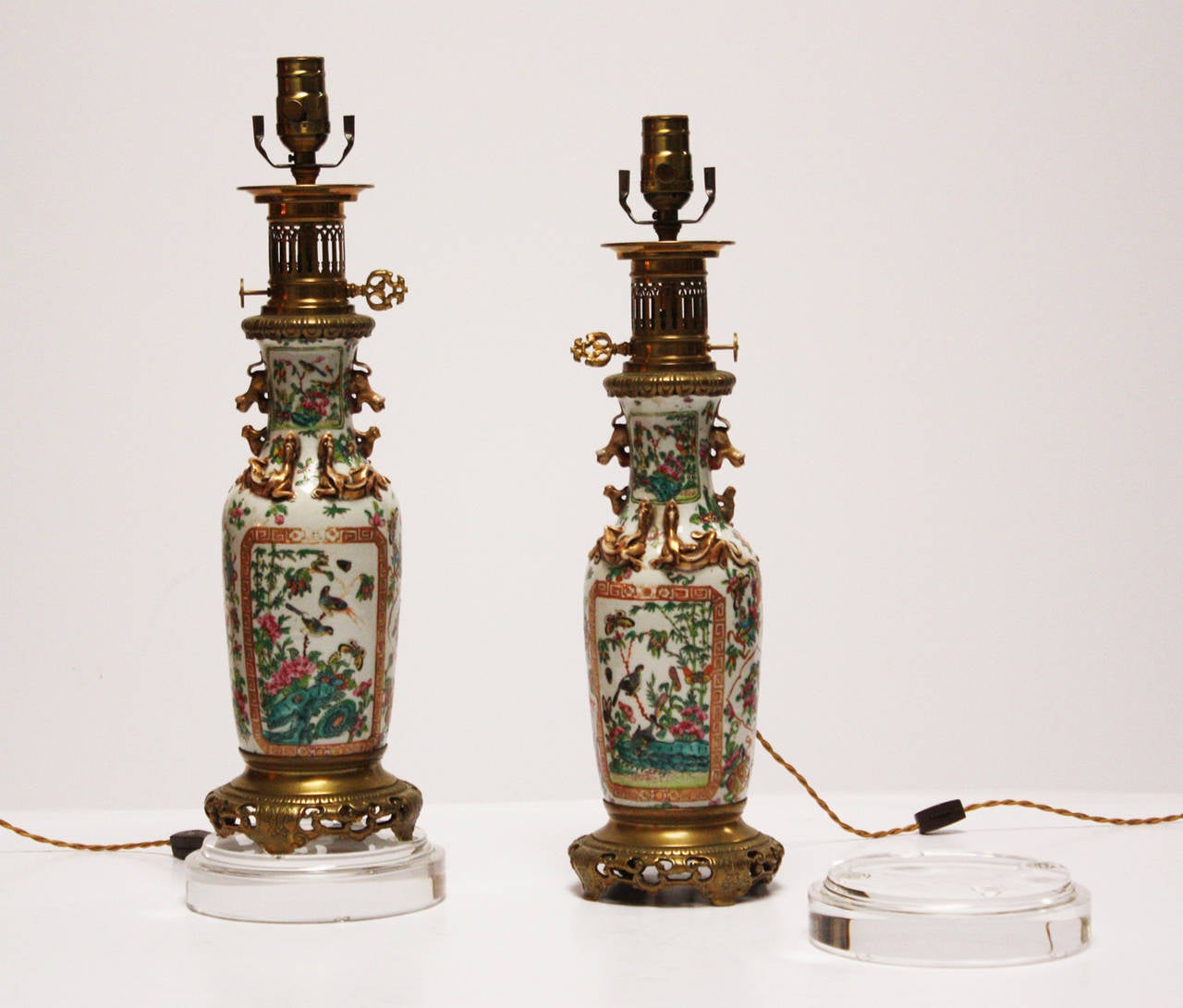 Pair of 19th century Chinese export rose medallion vases converted to 19th century French oil lamps with bronze mounts. The former oil lamps are now wired for electricity and rest on top of custom Lucite bases. The vases are beautifully painted with