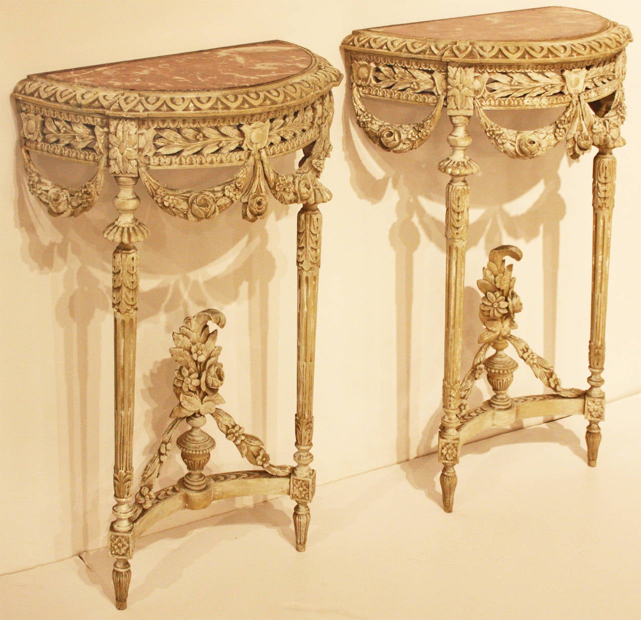 Pair of small French consoles in Louis XVI style from the early 19th century. Consoles have marble inserts on top and gray paint that has been refreshed.