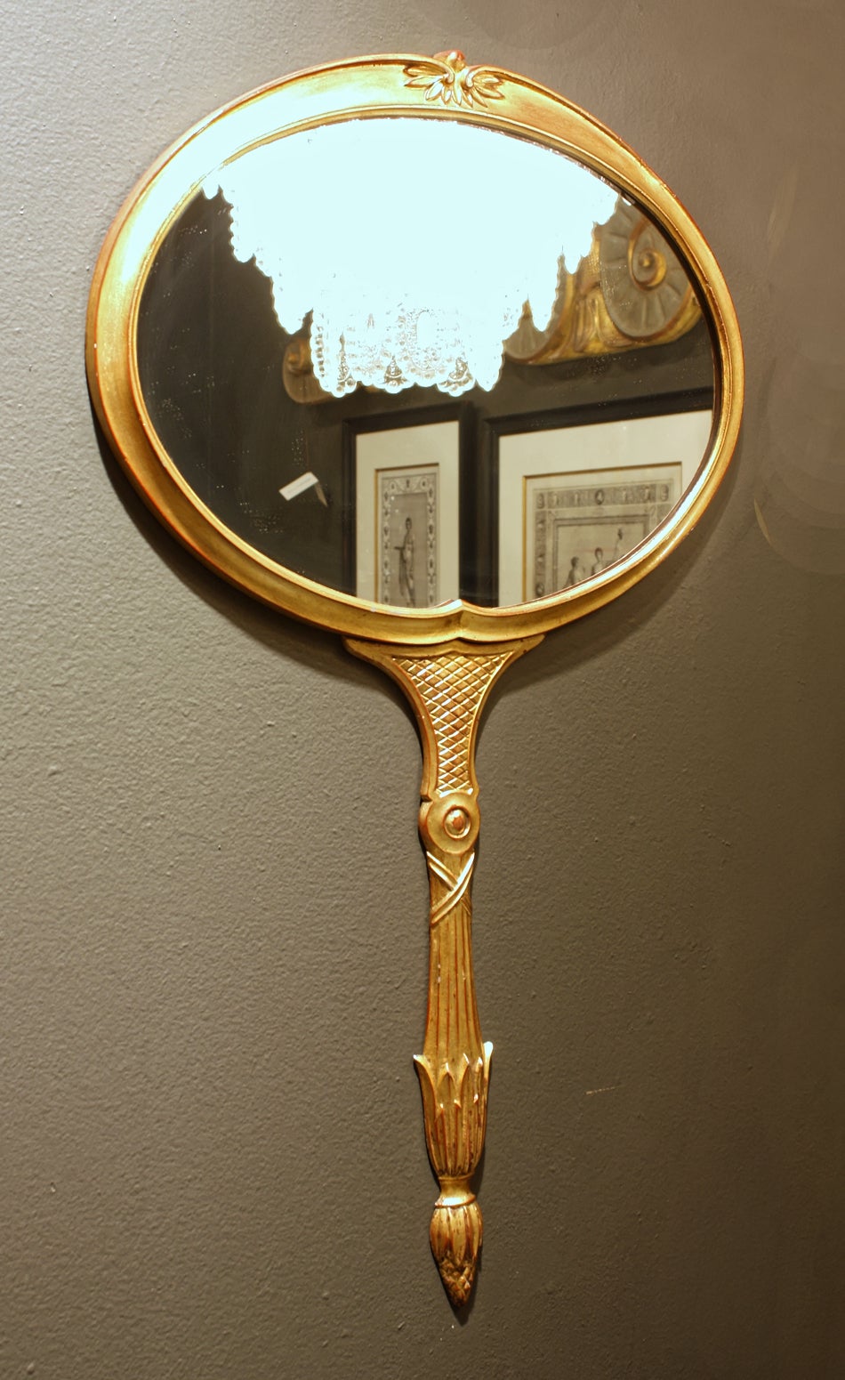 Pair of wall mirrors by Palladio in the style of Fornasetti, circa 1960. Cast metal with gilt finish in the shape of a hand mirror. Individual mirror available for $1,600.