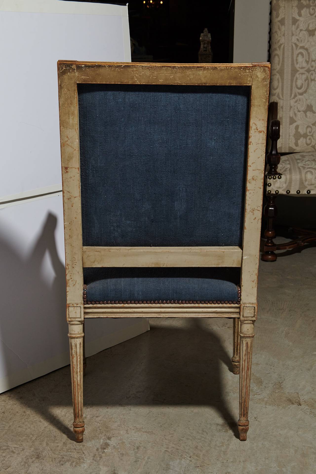 Pair of painted Louis XVI style armchairs from the mid-19th century. Large and comfortable scale. Upholstered in soft vintage handwoven European linen which has been dyed a beautiful blue. Original paint with a warm and natural patina. Nail head